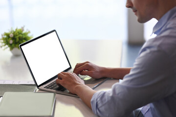 Businessman using laptop computer on office desk.