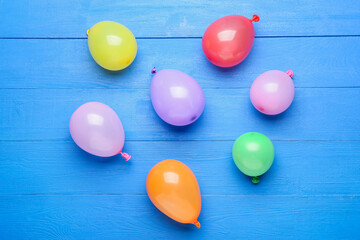 Beautiful balloons on color wooden background