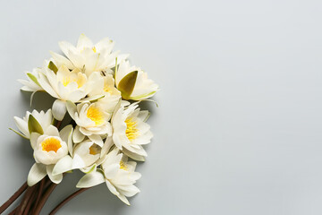 Fototapeta na wymiar Bouquet of beautiful blooming lotus flowers on grey background