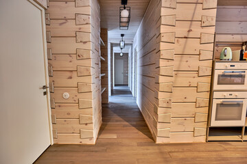 Interior of a corridor in a country house with natural wood walls and parquet