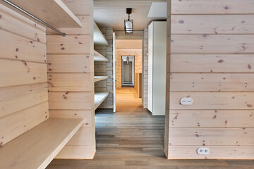 Interior of a corridor in a country house with natural wood walls and parquet