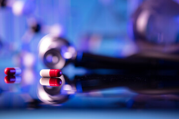 Laboratory investigations concerning test and medicine against covid. Microscope, shethoscope, glass tubes and beakers on blue background.