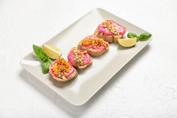 Plate with delicious vegetarian bruschettas and lime on light background