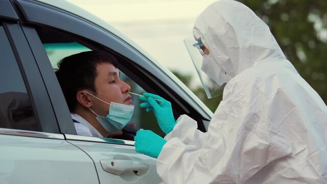 Doctor In PPE Suit Test Coronavirus(covid-19) To Man In Car By Nasal Swab Cotton, Drive Thru Test Fast Track