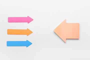 Colorful sticky notes in shape of arrows on white background