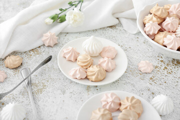 Plates with tasty meringues on grunge background