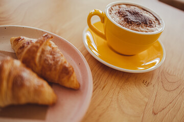 yellow coffee mugs on wooden table in cafe
