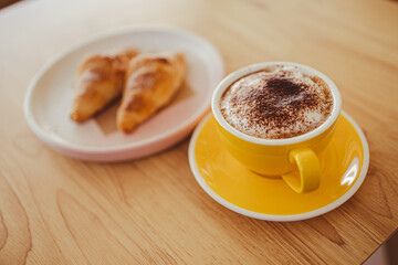 yellow coffee mugs on wooden table in cafe