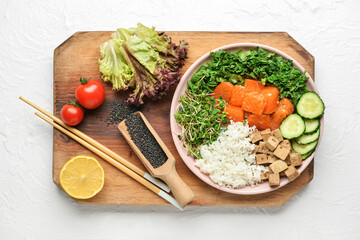 Plate with tasty rice, salmon, tofu cheese and vegetables on light background