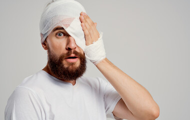 Obraz premium bearded man with bandaged head and eye hospitalization hospital medicine