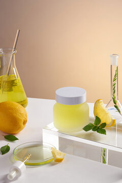 Lemon extract with transparent podium with test tube in color background , green leaf , sliced lemon for advertising , frontview , photography experiment concept 