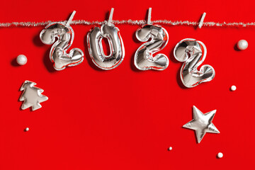 New Year 2022 silver balloons number and soft toys shape as Christmas tree and bright star, hanging...