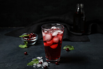 Glass with healthy cranberry juice on dark background