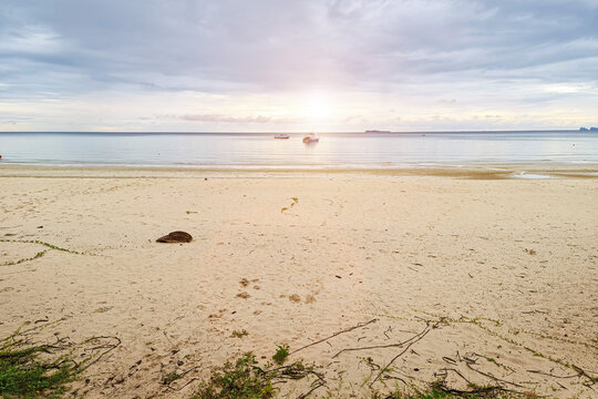 Travel slience peace tropical sea sand beach with morning sunrise in cloud sky and sun flare background in Thailand