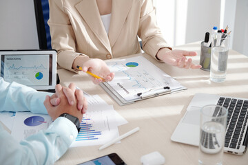 Cropped image of business people having meeting in office and discussing reports and strategy of development
