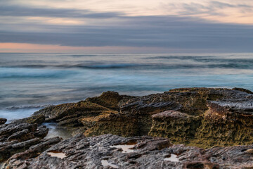 Fototapeta na wymiar Sunrise seascape with rocky foreground