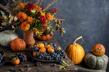Harvested pumpkins with fall leaves. Dark photo