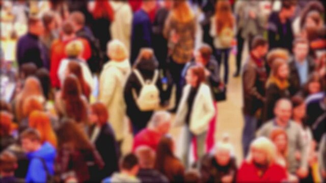 Crowd of people visiting the exhibition in bright demi-season clothes walk through the spacious halls of the mall pavilion.