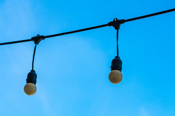 The hanging light bulbs with blue sky background