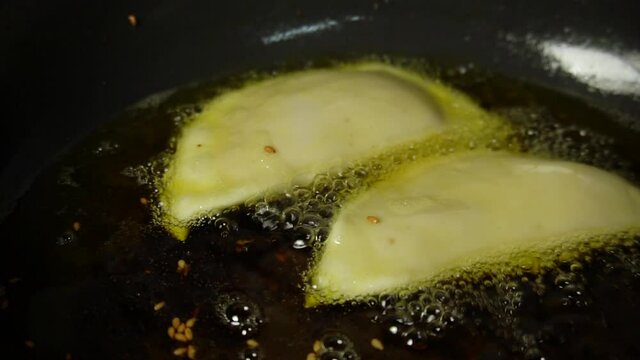"Karanji" deep frying in the oil, homemade preparation of Diwali faral in Maharashtra india. Also known as Gujiya or gujia.
