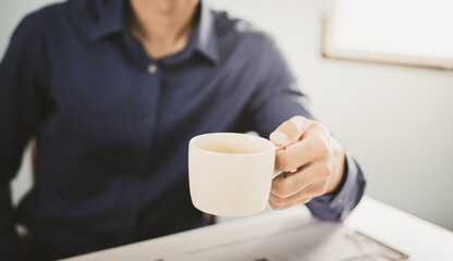 Business man holding a steaming cup of hot coffee