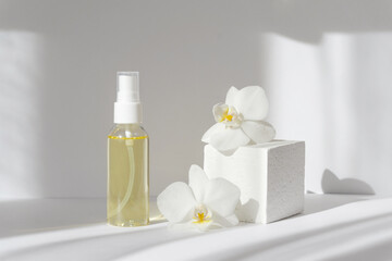 Fototapeta na wymiar Mock-up of glass bottle with essential oil and 3d podium with orchid flowers, on white background, in rays of sunlight. Concept of demonstration of products, spa treatments
