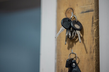 Car keys hanging on a wooden holder. Collection of keys ready to be taken.
