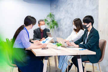 マスクをして会議をするビジネスパーソン
