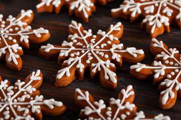 Fototapeta na wymiar Christmas background with homemade snowflake shape gingerbread cookies on wooden background. New Year celebration traditions concept.