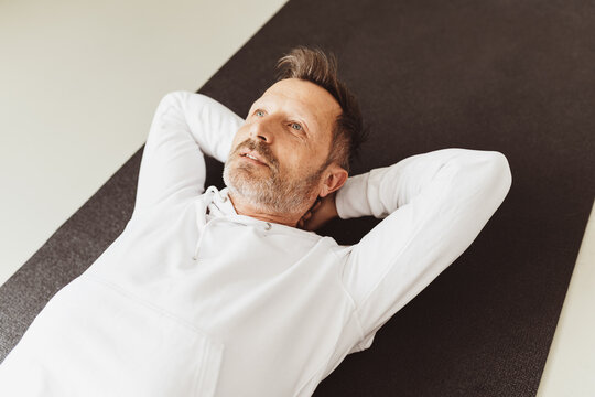 Man lying on his back on a carpet daydreaming