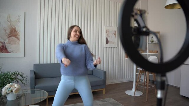 Teenager girl dancing at home when making video for social media. Popular trandy dance, young bloggers make content at home.