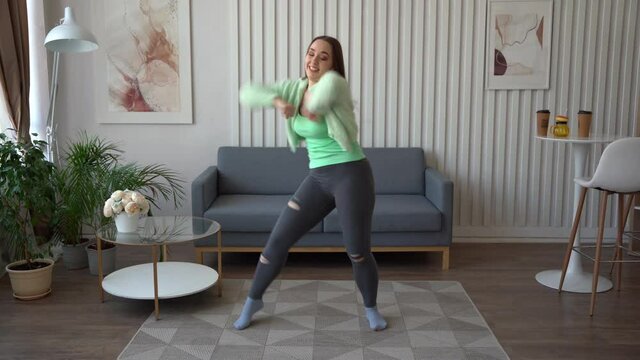 Girl dancing in the living room. Recording videostream video for social media at home.