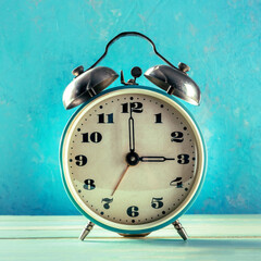 A retro alarm clock on a vibrant blue background, the concept of time, square image