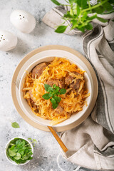 Braised (stewed) cabbage or bigos with turkey meat in a ceramic plate on a light culinary background. Traditional Polish dish	