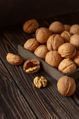 Still life of walnuts lying on a dark wooden table.