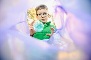 A seven-year-old boy at sunset is engaged in garbage collection in the park. Environmental care,...