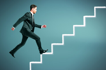 Attractive young european businessman running up on abstract stairs on grey background. Success and career growth concept.