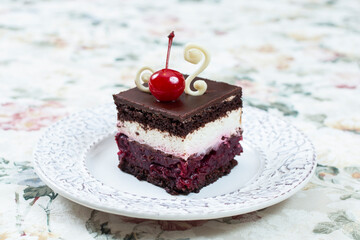 Chocolate cake with whipped cream and cherries on top