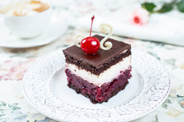 Chocolate cake with whipped cream and cherries on top