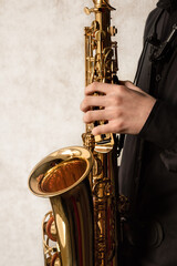 saxophonist holding alto saxophone, hands on the keys of the instrument, jazzman, learning to play...