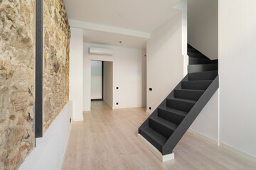 Refurbished apartment with restored ancient wall left from old city buildings. Interior of empty...