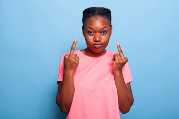 Portrait of african american student showing middle finger doing rebel expression at camera...