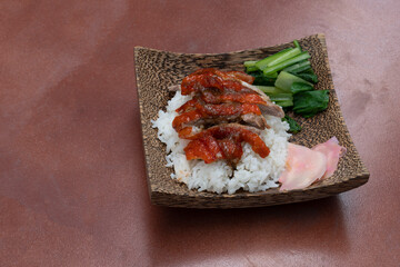 Best menu in Thailand. Rice crispy roast duck. With sliced ginger and mustard greens. Arrange dessert plates made of coconut. and orange tile background.