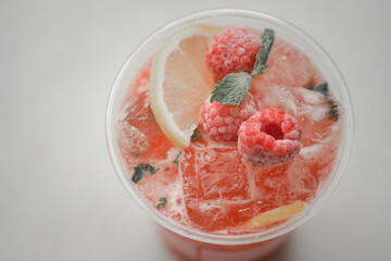 Summer refreshments in plastic glass decoration with slice lemon and berry