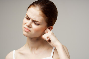 sick woman ear pain health problem dissatisfaction light background