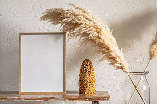 30x40 cm photo frame on a bench with pampas grass near the wall