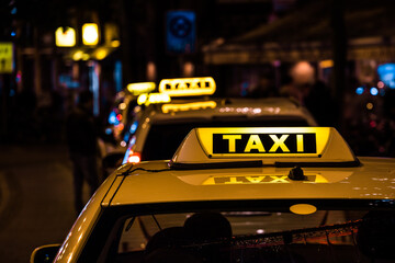Illuminated sign on the roof of a taxi at night