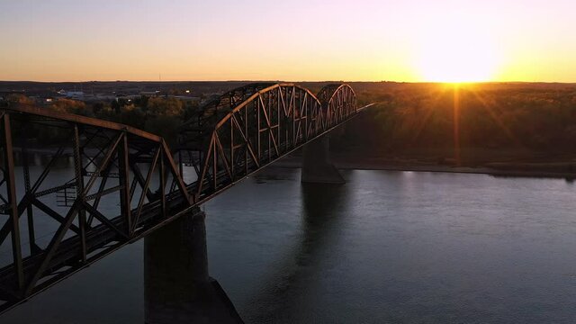 Flying along historic old railroad bridge in North Dakota at sunset over the Missouri River near Bismarck.