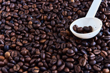 Coffee beans and a plastic spoon scattered on the table.