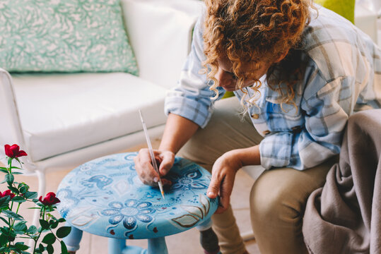 Artistic and creative woman paint at home for hobby and leisure time alone sitting on the chair. Hobby time leisure activity female people alone with colors